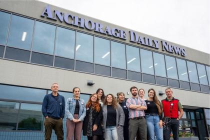 Photo of journalists smiling outside the office of the Anchorage Daily News