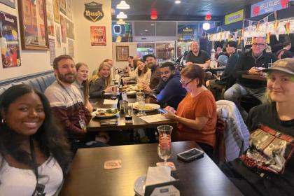A group of people smile at a restaurant